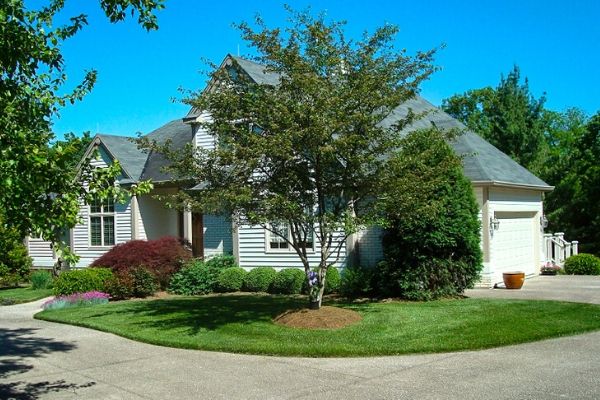 A suburban home with small but beautifully manicured lawn. Compton Lawn Care has mowed the grass and pruned the shrubs lining the house.